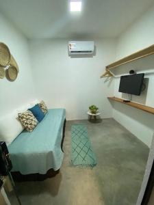 a living room with a bed and a tv at Casa Conchas do Patacho in Pôrto de Pedras