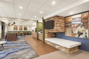 a lobby with a brick wall with a bench and a tv at Fairfield Inn by Marriott Warren Niles in Warren