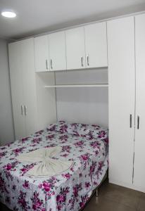 - une chambre avec un lit et une couverture fleurie dans l'établissement Apt 1 qto wifi - netflix - ar condicionado - prox ao metrô -ambiente familiar., à Ceilândia