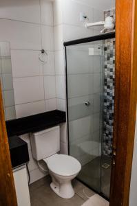 e bagno con servizi igienici e doccia in vetro. di Apt 1 qto wifi - netflix - ar condicionado - prox ao metrô -ambiente familiar. a Ceilândia