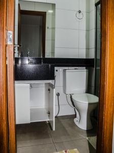 La salle de bains est pourvue d'un lavabo et de toilettes. dans l'établissement Apt 1 qto wifi - netflix - ar condicionado - prox ao metrô -ambiente familiar., à Ceilândia