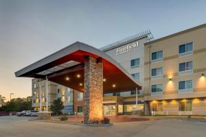 a hotel with a large building with a red roof at Fairfield Inn and Suites Hutchinson in Hutchinson