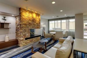 a living room with a couch and a stone fireplace at Fairfield Inn and Suites Hutchinson in Hutchinson