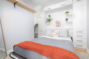 a white bedroom with a bed and white cabinets at Charming 1BD Townhouse Near Lake in Toronto