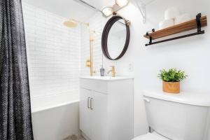 a bathroom with a toilet and a sink and a mirror at Charming 1BD Townhouse Near Lake in Toronto