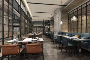 a restaurant with long tables and chairs and windows at Wuhan Marriott Hotel Hankou in Wuhan
