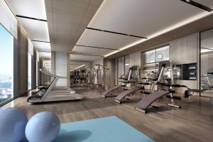 un gimnasio con cintas de correr y equipo cardiovascular en un edificio en Wuhan Marriott Hotel Hankou en Wuhan