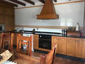eine Küche mit Holzschränken und einem Herd mit Backofen in der Unterkunft La Xana del Profundu in Villaviciosa + 13 Fotos