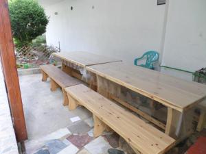 a row of wooden benches sitting next to a wall at Villa Nikolas in Paralia Katerinis