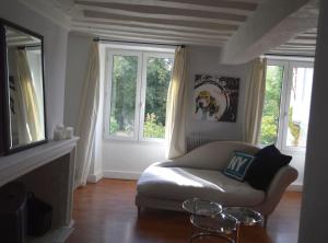 uma sala de estar com um sofá e duas janelas em Room in Guest room - Maison lAmerique welcome you to one of their rooms Dogs are also welcomed em Saint-Jean-le-Blanc