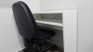 una sedia da ufficio nera seduta di fronte a una scrivania di Apt 1 qto wifi - netflix - ar condicionado - prox ao metrô -ambiente familiar. a Ceilândia