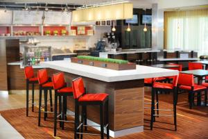 a bar with red stools in a restaurant at Courtyard by Marriott Oklahoma City Airport in Oklahoma City