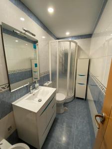 uma casa de banho com um chuveiro, um lavatório e um WC. em APARTAMENTO GOR em Granada