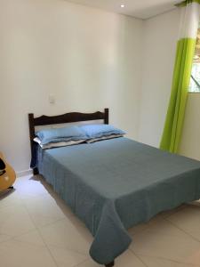 a bedroom with a bed with a green curtain at Casa do Fábio in Santana do Riacho