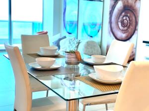 a glass table and chairs with cups and saucers on it at Monte Carlo Suites in Miami Beach in Miami Beach