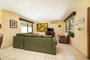 sala de estar con sofá verde y TV en Casa Luz de Luna - Comfortable 3 Br, 3,5 Bath house, en Potrero