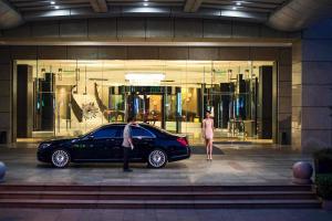 een zwarte auto geparkeerd voor een gebouw bij Renaissance Suzhou Hotel in Suzhou