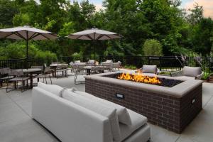 a fire pit with couches and tables and umbrellas at SpringHill Suites by Marriott Kalamazoo Portage in Portage