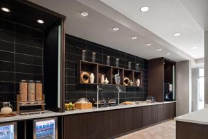 - une cuisine avec du carrelage noir et un comptoir avec de la nourriture dans l'établissement SpringHill Suites by Marriott Kalamazoo Portage, à Portage