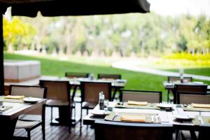 Renaissance Tianjin Lakeview Hotel في تيانجين: مجموعة طاولات وكراسي في مطعم
