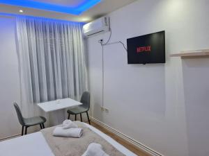 um quarto com duas camas e uma televisão na parede em Apartment in the heart of Tirana em Tirana
