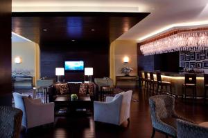 a lobby with a bar with chairs and a television at Courtyard by Marriott Kunshan in Kunshan