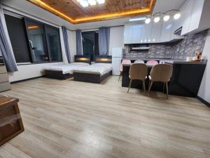Unseo Station 10mins - Max 6pax, BBQ في انشيون: غرفة كبيرة مع مطبخ وغرفة مع طاولات وكراسي