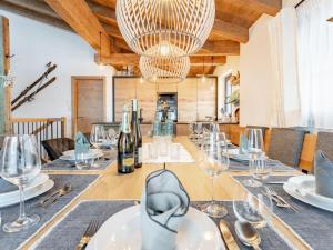 une salle à manger avec une table, des verres à vin et un lustre dans l'établissement Tauernlodge Carpe Diem, à Niedernsill