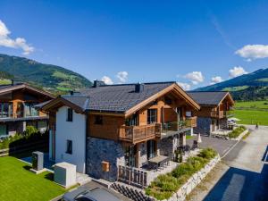 eine Luftansicht eines Hauses mit Bergen im Hintergrund in der Unterkunft Tauernlodge Carpe Diem in Niedernsill