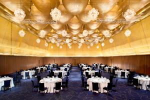 un salón de banquetes con mesas blancas y sillas negras en Le Meridien Zhengzhou en Zhengzhou