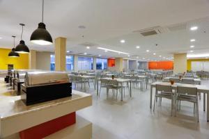 a restaurant with tables and chairs in a cafeteria at Apartamento do lado do Thermas dos laranjais no Olímpia Park resort in Olímpia +9 photos