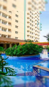 a view of a building with blue water and plants at Apartamento do lado do Thermas dos laranjais no Olímpia Park resort in Olímpia