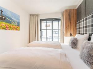 a hotel room with two beds and a window at Tauernlodge Chalet Salzach in Niedernsill