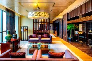 uma sala de estar com um sofá e um lustre em The Westin Beijing Chaoyang em Pequim