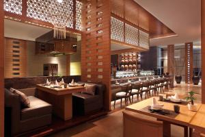 a restaurant with tables and chairs and a bar at Sheraton Hefei Xinzhan Hotel in Hefei