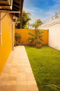 a walkway in a yard with a yellow wall at Chalé 31 in Florianópolis