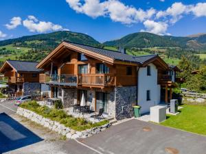 a house in the mountains with a parking lot at Tauernlodge Chalet Salzach in Niedernsill