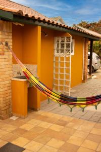 a yellow house with a hammock in front of it at Chalé 31 in Florianópolis