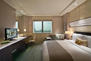 Pokój hotelowy z dużym łóżkiem i telewizorem w obiekcie Courtyard By Marriott Shanghai Pudong w Szanghaju