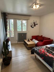 a living room with a red couch and a table at Appartement jolie vue WIFI in Besançon