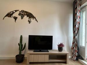 a living room with a tv and a world map on the wall at Appartement jolie vue WIFI in Besançon