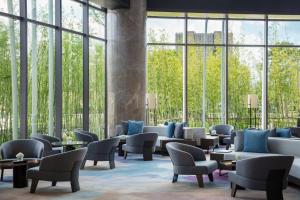 a lobby with chairs and tables and large windows at Hangzhou Marriott Hotel Lin'an in Lin'an