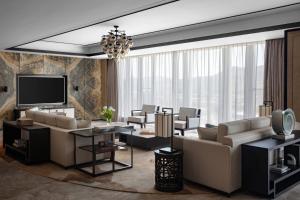 a living room with couches and a flat screen tv at Hangzhou Marriott Hotel Lin'an in Lin'an