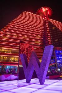 um grande edifício com um sinal roxo em frente em W XIAN Hotel em Xi'an