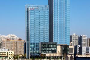 a tall glass building in a city with buildings at Courtyard By Marriott Xi'an North in Xi'an