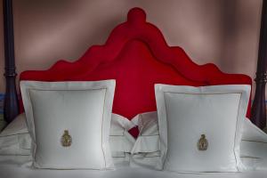a bed with two white pillows with a red headboard at Villa Cora in Florence