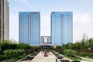 two tall buildings in the middle of a city at Sheraton Qingdao Jiaozhou Hotel in Jiaoxian