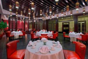 un comedor con mesas, sillas rojas y mesa en Sheraton Fuzhou Hotel, en Fuzhou