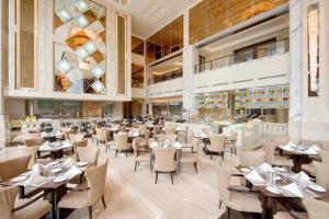 a dining room with tables and chairs and a restaurant at Sheraton Qingdao Jiaozhou Hotel in Jiaozhou