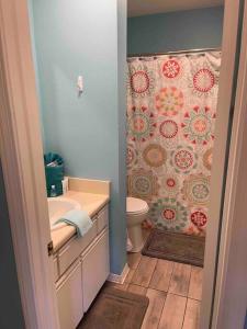 a bathroom with a toilet and a shower curtain at Wanderlust Villa only 3 min walk to the Sand! in Panama City Beach